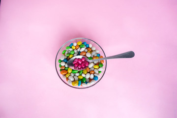 Glass bowl on pink background. bowl glass isolated. top view, copy space. Colorful candies