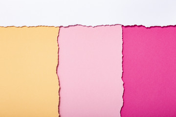 abstract background of multi-colored stripes of torn cardboard lying vertically, top view