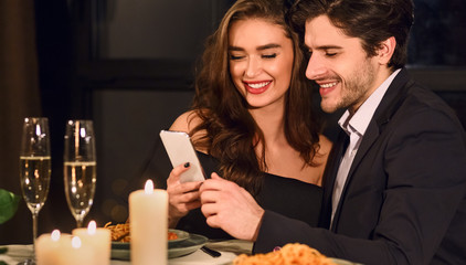 Lovely young couple looking at smartphone