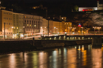Fototapeta na wymiar Stadt am Fluss bei Nacht mit Beleuchtung und Lichtstreifen