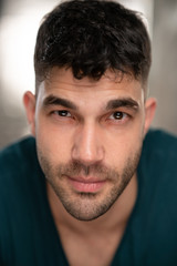 Obraz premium Handsome caucasian white male with black short hair and stubble with blue t shirt flirting