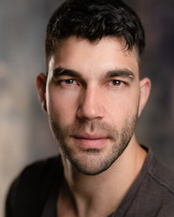 Handsome caucasian white male with black short hair and stubble with brown t shirt