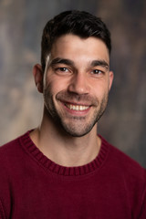 Fototapeta premium Handsome caucasian white male with black short hair and stubble and burgundy sweater jersey