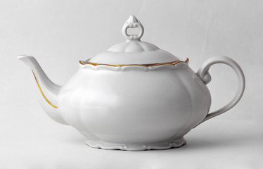 White teapot with golden rim in classic style isolated on white background with clipping path.