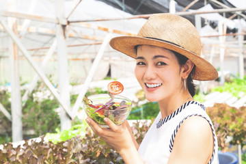 Healthy asian woman holding salad bowl with tomato sliced. Happy lifestyle