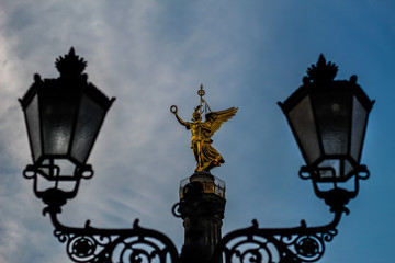 Fototapeta na wymiar Die Statue Viktoria auf der Siegessäule zwischen zwei Laternen