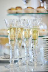 Catering services. Glasses with wine in row background at restaurant party. Clean plates and cutlery on white table 