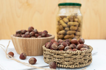 he concept of tree nuts and peanuts. In a glass jar, wicker basket and wooden bowl.