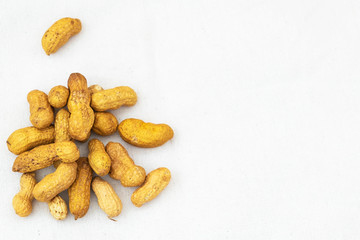 Peanuts in the peel in a pile on linen fabric. Minimalism. Place for text