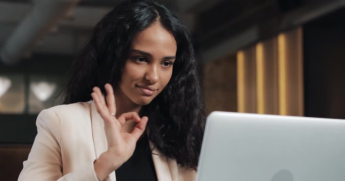 Young business woman having video call with her boss on laptop at the modern office. Beautiful woman talking to camera, online video chat