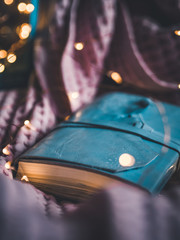 Moodie still life with blue lantern, handmade notebook and copper garland