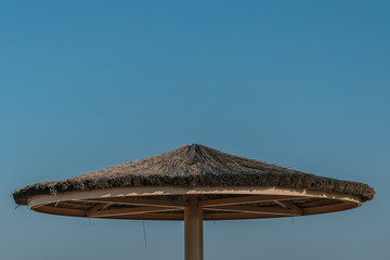 Round roof of reeds from the sun against the sky.