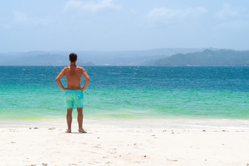 Man standing on the white beach in front of the ocean, cayo levantado, caribbean sea