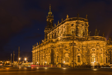 Fototapeta na wymiar Aufnahme einer beleuchteten Kirche mit Turm bei Nacht in der Stadt mit brennenden Straßenlampen 