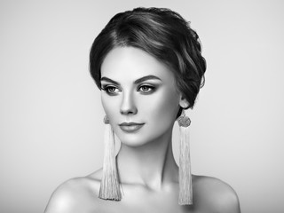 Beautiful Woman with Large Earrings Tassels jewelry. Perfect Makeup and Elegant Hairstyle. Fashion Make-up Arrows. Black and White Photo
