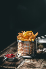 French fries in a basket with ketchup - 246185748