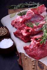 Raw beef ribs, rosemary, thyme and spices on a wooden board