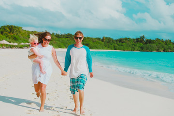 happy family with little baby daughter play run on beach