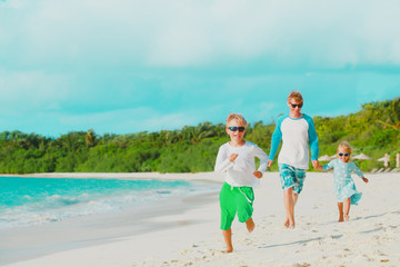 happy father with little son and daughter walk at beach