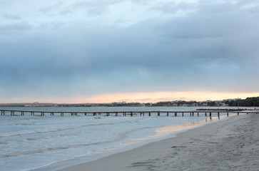 Leerer Strand bei Dämmerung, die Sonne spiegelt sich im Meereswasser, copy space unten