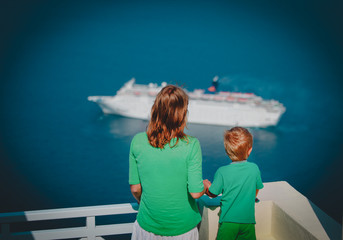 mother and little son looking at cruise ship at sea, Santorini, Greece
