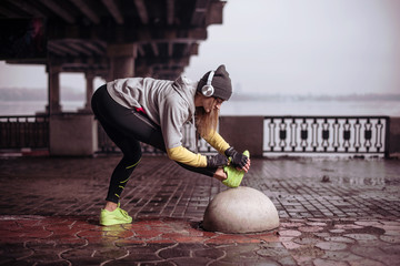 Potrtait of young woman athlete doing exercises at morning in winter