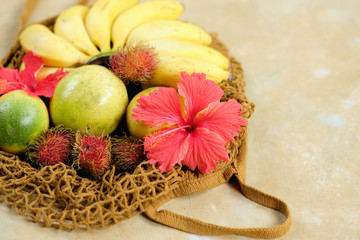 Banana Rambutan Flower Composition Top Down View. Tropical Detox Fruit in Basket Flatlay Above Shot. Organic Sweet Vegetarian Breakfast for Vacation Lifestyle. Ripe Fresh Summer Food