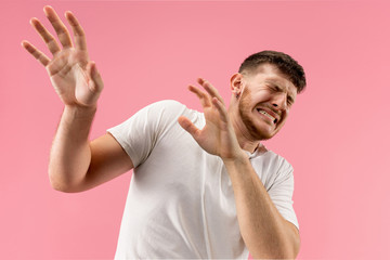 I'm afraid. Fright. Portrait of the scared man. Business man standing isolated on trendy pink...