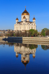 Fototapeta na wymiar Cathedral of Christ the Saviour with reflection on water surface of Moskva river at sunny spring morning