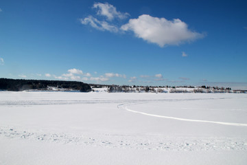 winter landscape with frozen lake and blue sky