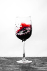 Red wine in the glass splashes in action on a white background. Design card