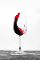 Red wine in the glass splashes in motion on a white background. Stylish design drink card