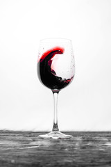 Red wine in the glass splashes in motion on a white background. Stylish design drink card