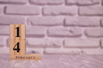 14 february set on wooden calendar with white brick background. Happy Valentines day