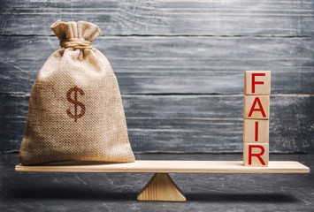 Money bag and wooden blocks with the word Fair. Balance. Fair value pricing, money debt. Fair deal....