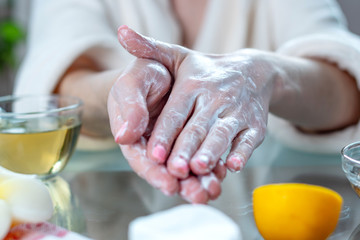 Woman applying the cream on hands moisturizing and nourishing them with natural cosmetics. Hygiene and care for the skin
