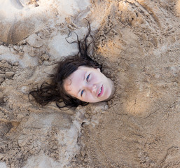 Art photo of beautiful lady buried in the sand