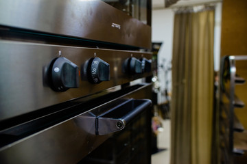 Close up of oven knob on metal board dial of a stainless steel electric oven
