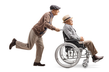 Elderly man pushing a man in a wheelchair