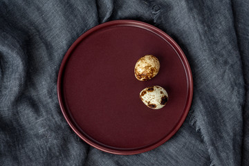 Two quail eggs on a plate, diet. Minimalism, top view.