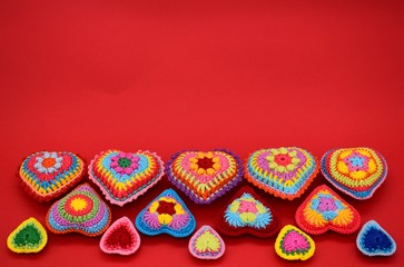 Fototapeta na wymiar Valentine's day. Background of hearts on a red background. Amigurumi, handmade, knitted.