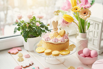 Easter composition with sweet bread, Easter cake, eggs, bouquet of flowers. Holidays breakfast concept with copy space. Traditional easter cake with gingerbread cookies. Easter Greeting Card Template