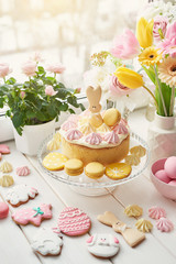 Easter composition with sweet bread, Easter cake, eggs, bouquet of flowers. Holidays breakfast concept with copy space. Traditional easter cake with gingerbread cookies. Easter Greeting Card Template