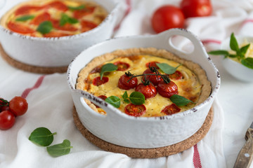 Homemade quiche with tomatoes, chicken, basil leaves and cheese. Close up