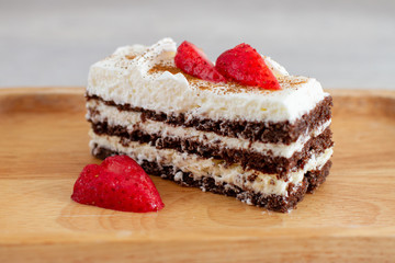 piece of cake with strawberry on wooden board
