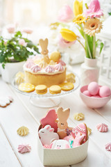 Easter composition with sweet bread, Easter cake, eggs, bouquet of flowers. Holidays breakfast concept with copy space. Traditional easter cake with gingerbread cookies. Easter Greeting Card Template