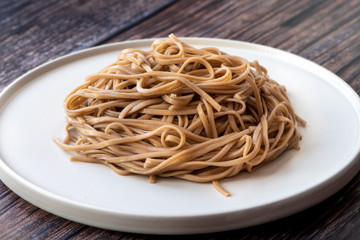 Cooked soba noodles on a white plate.
