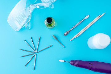 Set of cosmetic tools for professional hardware manicure on a blue background. Milling cutter, top view