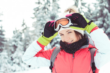 Fototapeta na wymiar Happy young woman skier enjoying winter in mountains