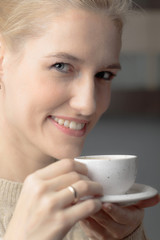 Close-up portrait of a beautiful mid age woman with cup of coffee.